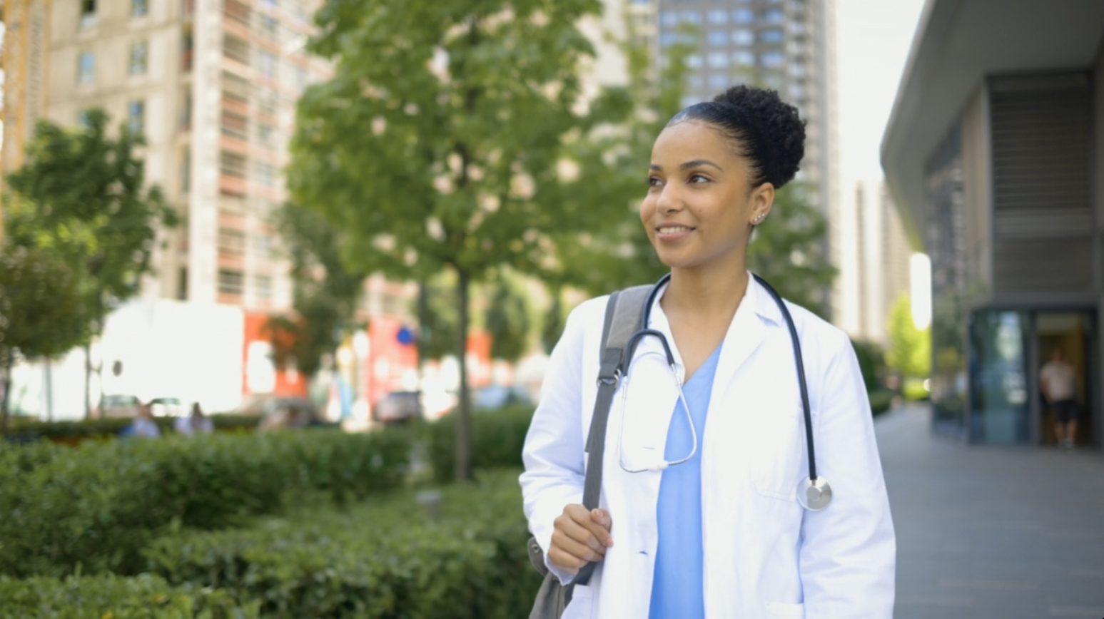 Doctor walking out of hospital enjoying nature