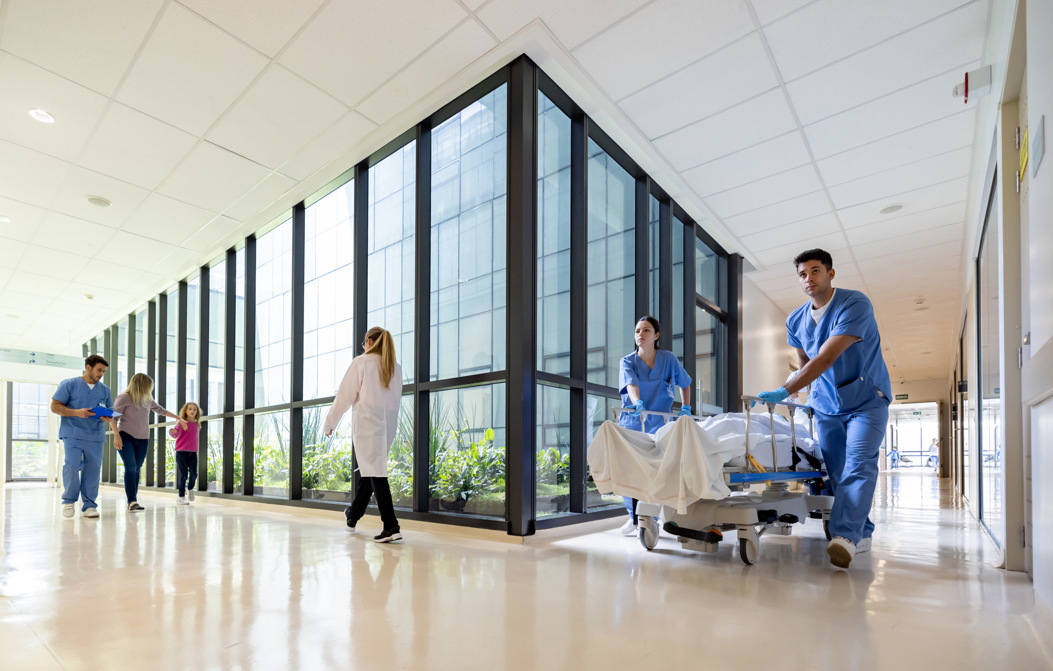 Latin American doctors assisting patients at the hospital and carrying one on a gurney - healthcare and medicine concepts